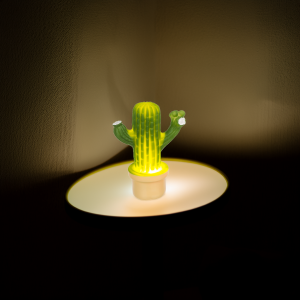 Cactus-shaped lamp glowing softly in a dimly lit room.